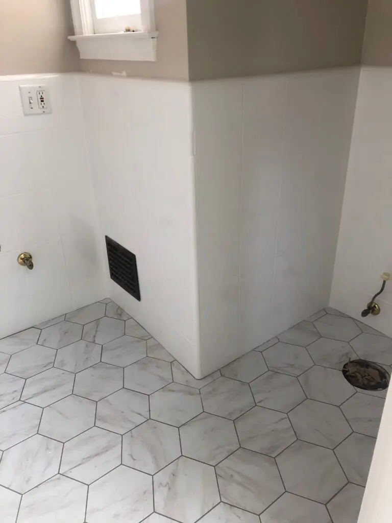 an unfinished bathroom with white walls and white hexagonal tiles